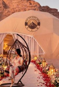 a woman sitting in a swing in a tent at WADI RUM DESERt MOON in Wadi Rum