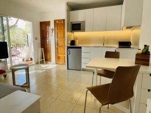 a kitchen with white cabinets and a table and chairs at Stunning Intimate views. Terrace Rooftop. Wifi in Tamariu