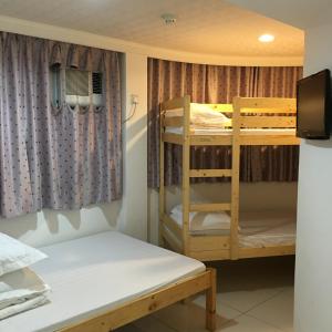 a room with two bunk beds and a tv at Le Cong Fraternal Guest House in Hong Kong