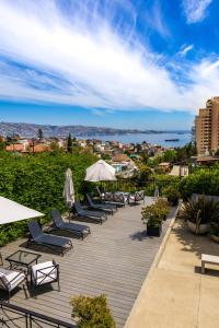 a row of lounge chairs and umbrellas on a deck at Hotel Boutique Casa Recreo in Viña del Mar