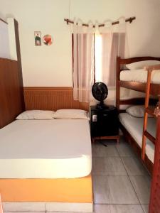 a bedroom with two bunk beds and a window at Hospedagem Jabuti no Centro de São Jorge in Sao Jorge