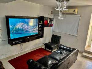 a living room with a couch and a flat screen tv at Duplex DEL CARMEN in Santiago del Estero