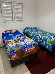 two beds sitting next to each other in a room at Duplex DEL CARMEN in Santiago del Estero