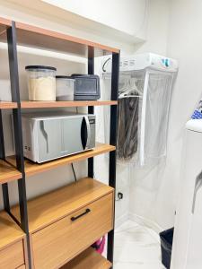a kitchen with wooden shelves and a microwave at Centro de Vitoria in Vitória