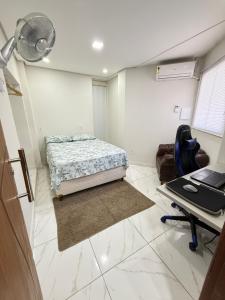 a bedroom with a bed and a desk with a laptop at Centro de Vitoria in Vitória +10 photos