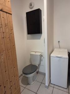 a bathroom with a toilet and a tv on the wall at Le Cocon Litois in Lit-et-Mixe