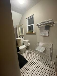 a bathroom with a toilet and a black and white tile floor at The Hideaway in Cleveland +4 photos