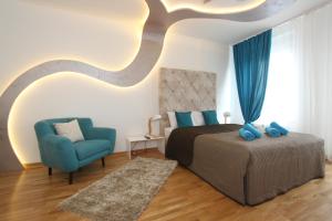una camera con letto e sedia blu di Riviera 2 New Belgrade studio apartment, parking 5 evra dan a Belgrado