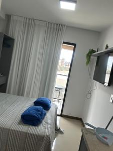 a bedroom with a bed with blue pillows on it at Studio nascente na Pituba in Salvador +19 photos