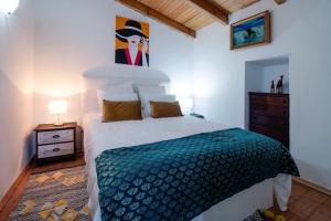 a bedroom with a bed and a painting on the wall at Casa Da Maria - Villa with Private Pool and Barbecue in Fonte do Bispo +14 photos