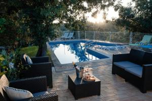 a patio with couches and a pool with a table at Casa Da Maria - Villa with Private Pool and Barbecue in Fonte do Bispo