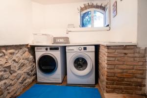 a washer and dryer sitting next to a brick wall at Casa Da Maria - Villa with Private Pool and Barbecue in Fonte do Bispo