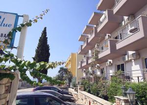 Eine Reihe von Autos parkt vor einem Gebäude in der Unterkunft Mare Blue Hotel Drymades in Dhërmi