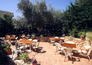 eine Terrasse mit Tischen und Stühlen und einem Baum in der Unterkunft Mare Blue Hotel Drymades in Dhërmi + 11 Fotos
