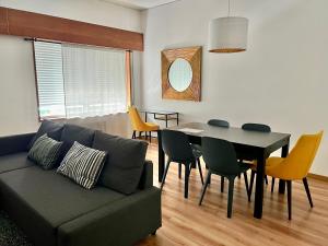 a living room with a couch and a table and chairs at Lisboa Apart. Central e Espaçoso - Parque e Metro in Lisbon