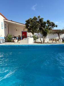 a swimming pool with blue water in front of a house at Canto da Planície in Conceição +77 photos