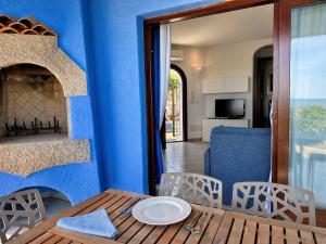 a dining room with a table and a blue wall at Villa Azzurra in Cannigione