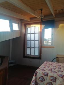 a bedroom with two windows and a bed in it at Habitación tu Refugio in Isla Negra