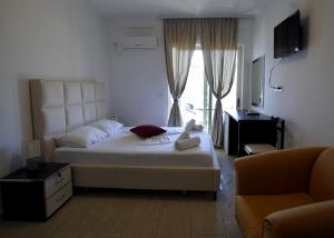 ein Schlafzimmer mit einem großen Bett und einer Couch in der Unterkunft Mare Blue Hotel Drymades in Dhërmi