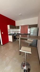 a kitchen with a table and two stools in it at Casa en planta alta in Rosario +6 photos