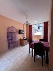 a living room with a dining room table and a tv at Minidpto Wayra Huanchaco in Huanchaco
