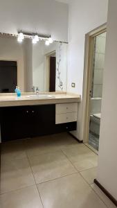 a bathroom with a sink and a large mirror at Casa en planta alta in Rosario