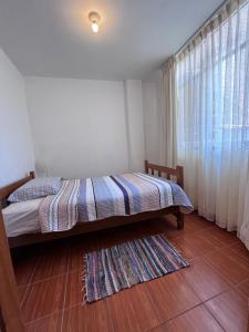 a bedroom with a bed and a large window at Minidpto Wayra Huanchaco in Huanchaco