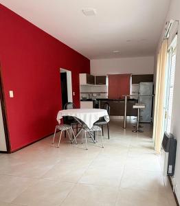 a room with a table and a red wall at Casa en planta alta in Rosario