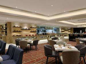 a restaurant with tables and chairs and a buffet at Novotel Lucknow Gomti Nagar in Lucknow