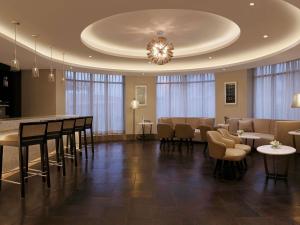 a waiting room with tables and chairs and a chandelier at Novotel Lucknow Gomti Nagar in Lucknow