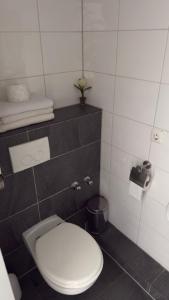 a bathroom with a white toilet in a room at Hotel Alden in Aldenhoven