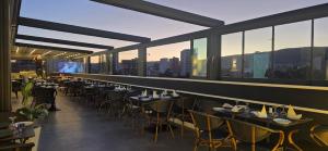 a restaurant with tables and chairs with a view of the city at Lounis Hôtel by Atlantis in Oran