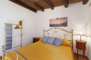a bedroom with a yellow bed with blue pillows at Villa Gheta At The Monte Cofano in Custonaci