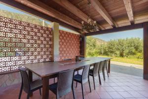 a table and chairs on a patio with a view at Villa Gheta At The Monte Cofano in Custonaci
