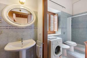 a bathroom with a sink and a washing machine at Villa Gheta At The Monte Cofano in Custonaci +30 photos