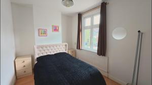 a bedroom with a bed and a window at Spacious modern apartment in South Croydon in Purley