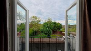 an open window with a view of a yard at Spacious modern apartment in South Croydon in Purley