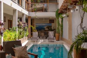 a patio with a pool and chairs and a table at Terra Bella Pousada in Morro de São Paulo