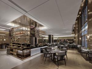 a restaurant with tables and chairs and a bar at DoubleTree By Hilton Cangnan in Hengpu