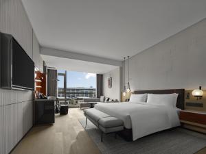 a bedroom with a large white bed and a couch at DoubleTree By Hilton Cangnan in Hengpu