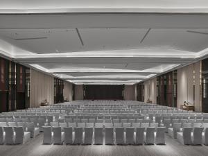 an empty hall with white chairs and a stage at DoubleTree By Hilton Cangnan in Hengpu +81 photos