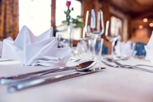 a table with silverware and napkins on a white table at Hotel Restaurant Stöcklwirt in Sankt Johann im Pongau