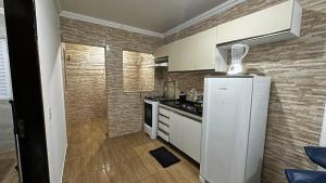 a kitchen with a white refrigerator in a room at Flat Maracarib um espaço todo seu próximo de tudo in Maragogi