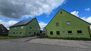 two green houses sitting next to each other at Apartment Leidenberger - Nähe Rothenburg & Ansbach - 2 Schlafzimmern in Colmberg