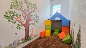 a childs room with a wall mural of a tree at Apartment Leidenberger - Nähe Rothenburg & Ansbach - 2 Schlafzimmern in Colmberg