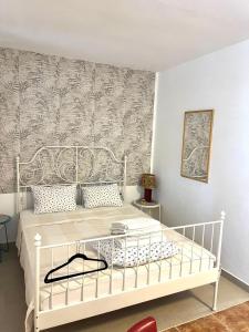a bedroom with a white bed and a wall at Mika Studio in Tivat