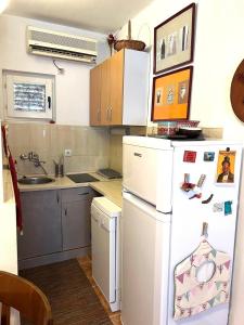 a kitchen with a white refrigerator and a sink at Mika Studio in Tivat +2 photos