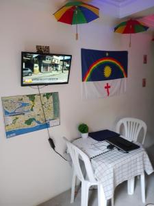 a room with a table and a tv on a wall at Boa Viagem Inn Pousada in Recife