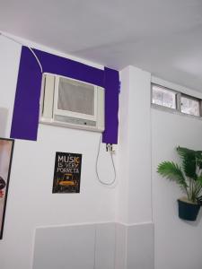 a room with a heater and a sign on the wall at Boa Viagem Inn Pousada in Recife
