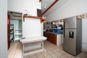 a kitchen with a white counter and a refrigerator at Casa Osú in Sámara